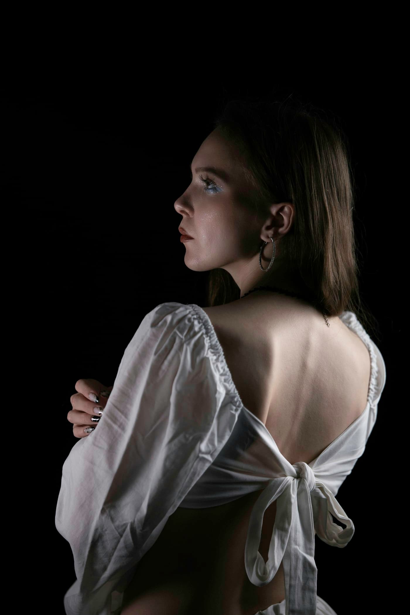 Model in an ivory blouse with an open back