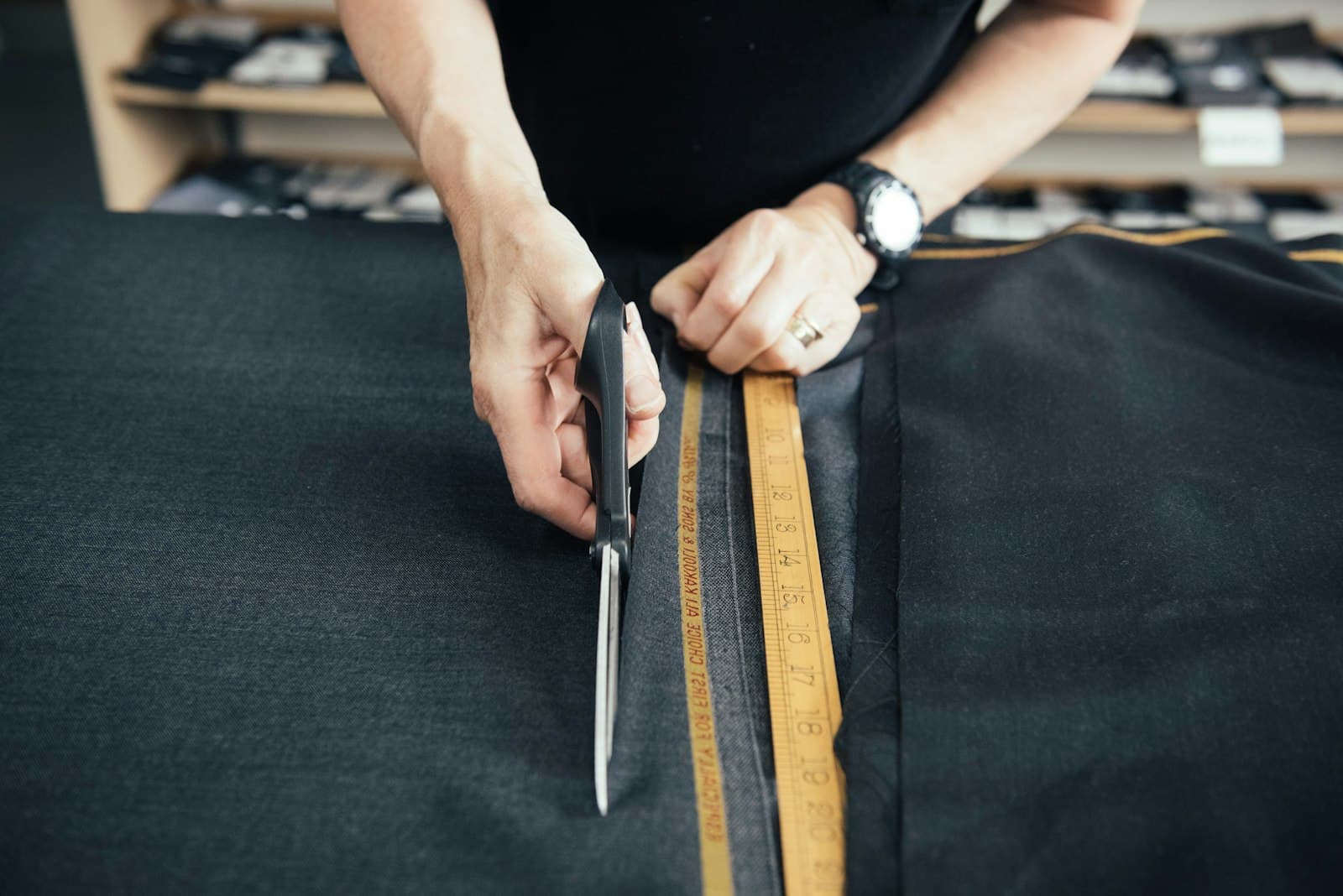 A tailor cutting dark wool with heavy shears