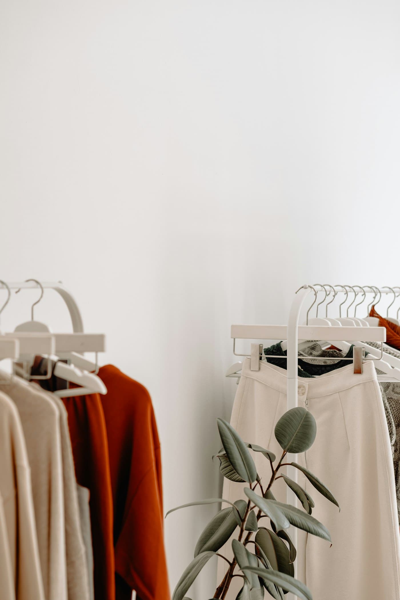 Garments hanging on a rail beside pinned photographs