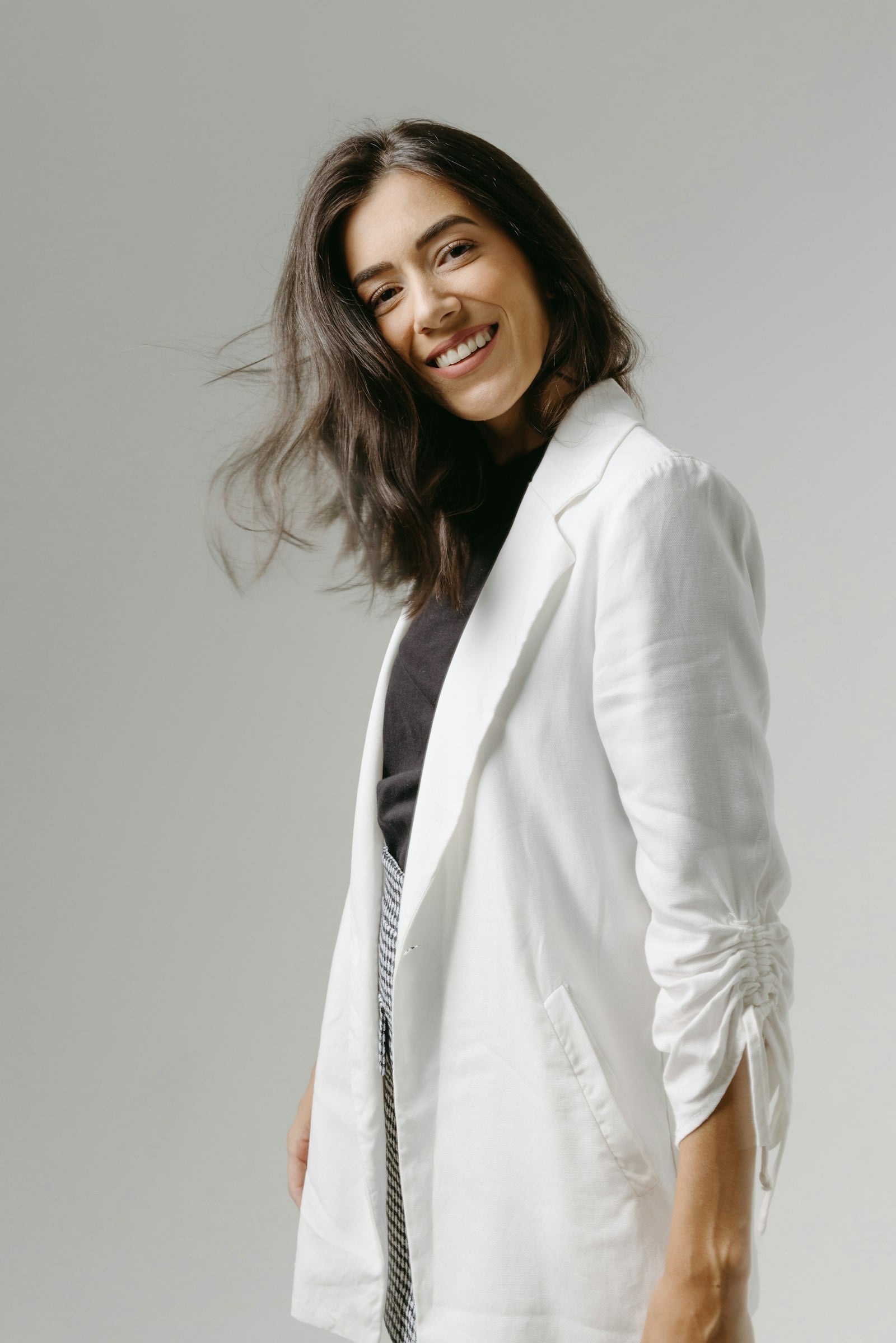 Woman in an ivory linen blazer and scarf in warm natural light